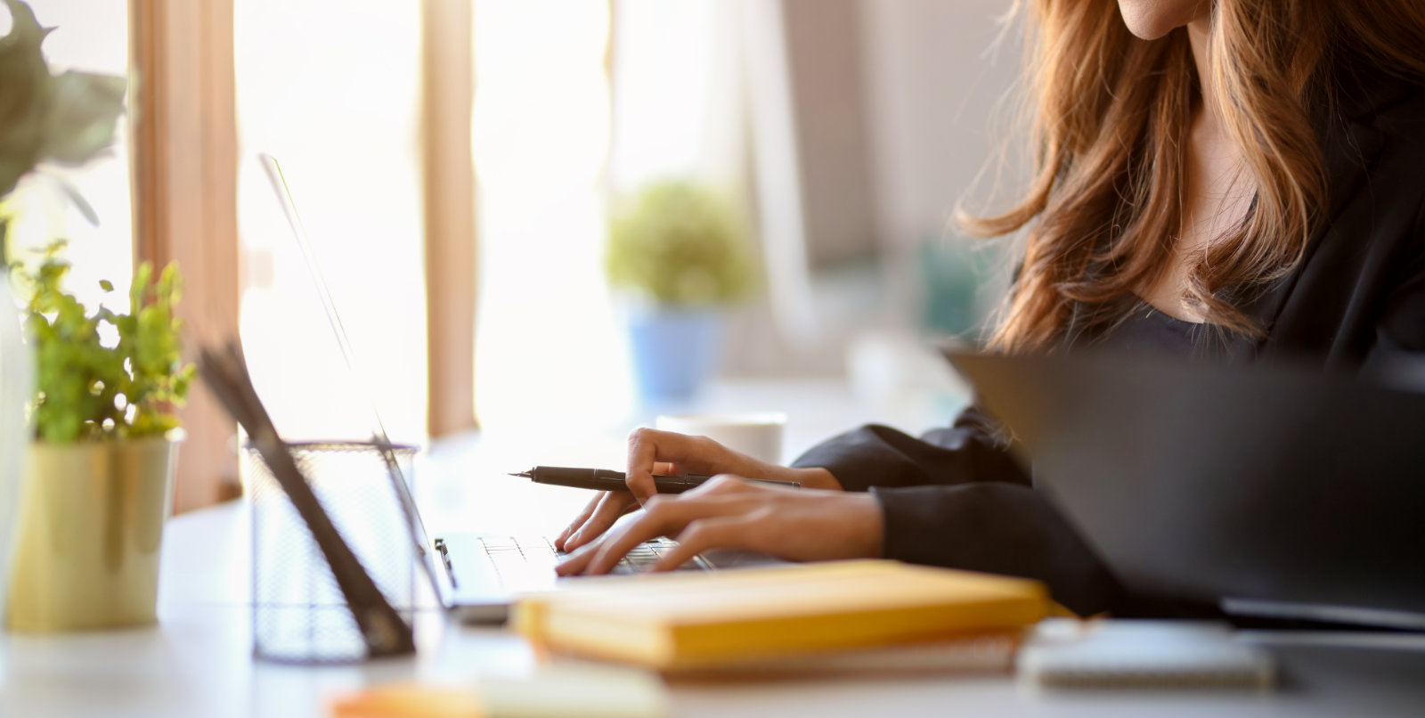 Cropped image of a beautiful asian woman using laptop computer. Business woman typing on notebook computer keyboard.